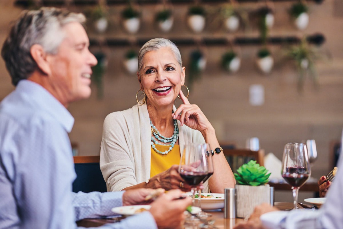 A group of people enjoying a meal and conversation at a restaurant.