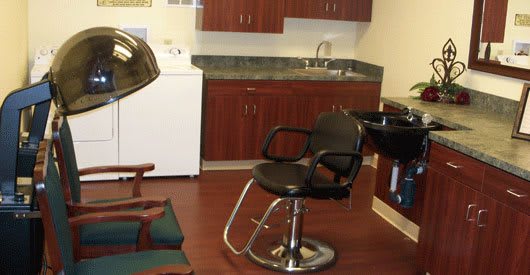A hair salon interior with a barber chair and styling equipment.