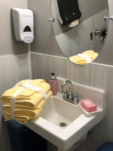 A neatly arranged bathroom setup with yellow towels, soap, and a mirror.