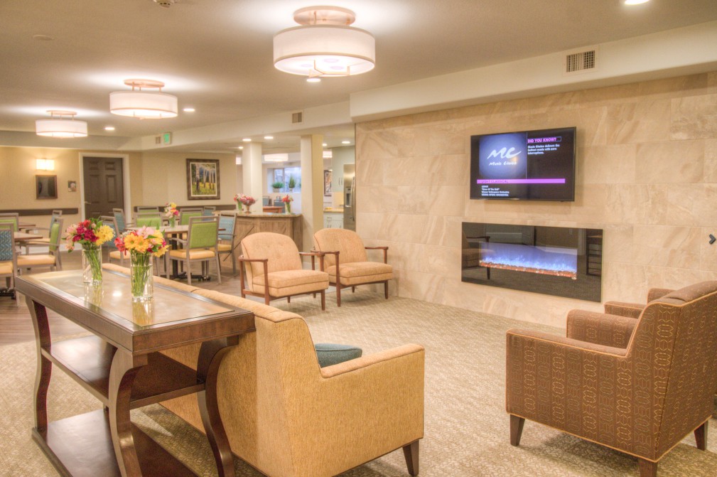 A modern lobby with comfortable seating, ambient lighting, and a television on the wall.