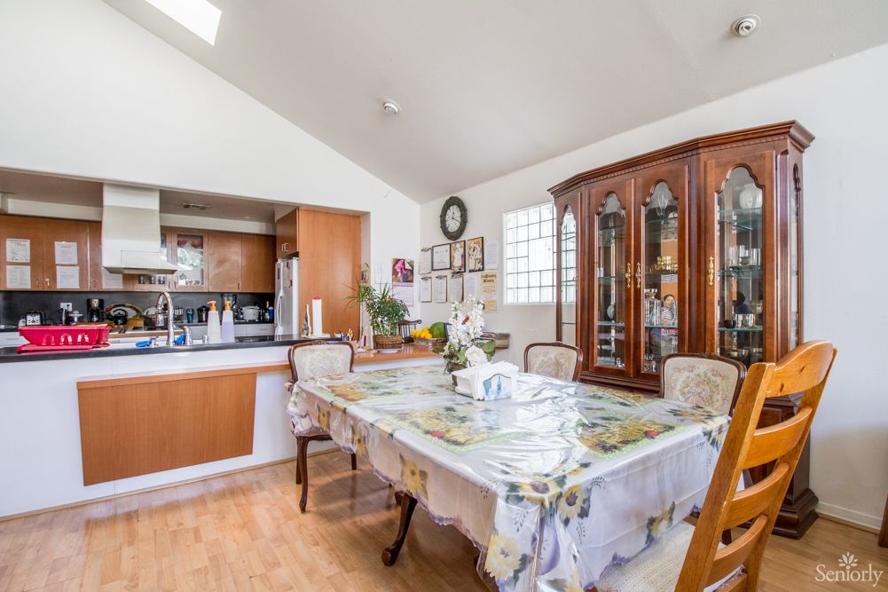 A cozy dining room with a well-set table and adjoining kitchen.