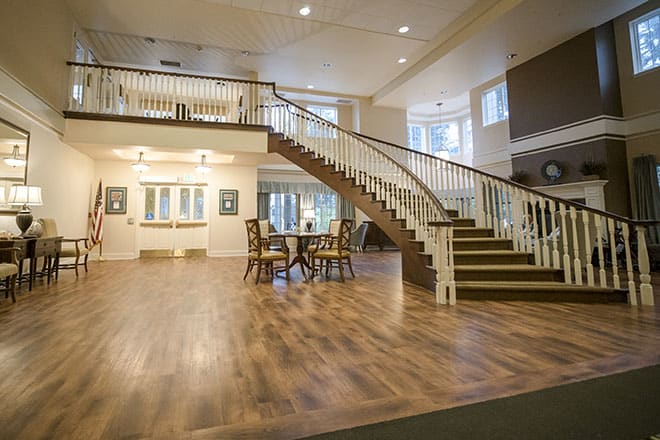 A spacious interior with a grand staircase and wooden flooring.