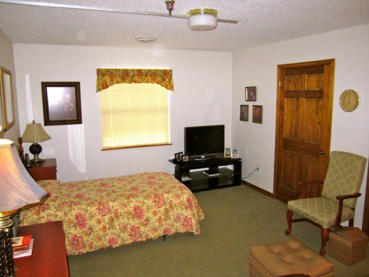 A cozy bedroom with a bed, television, and window.