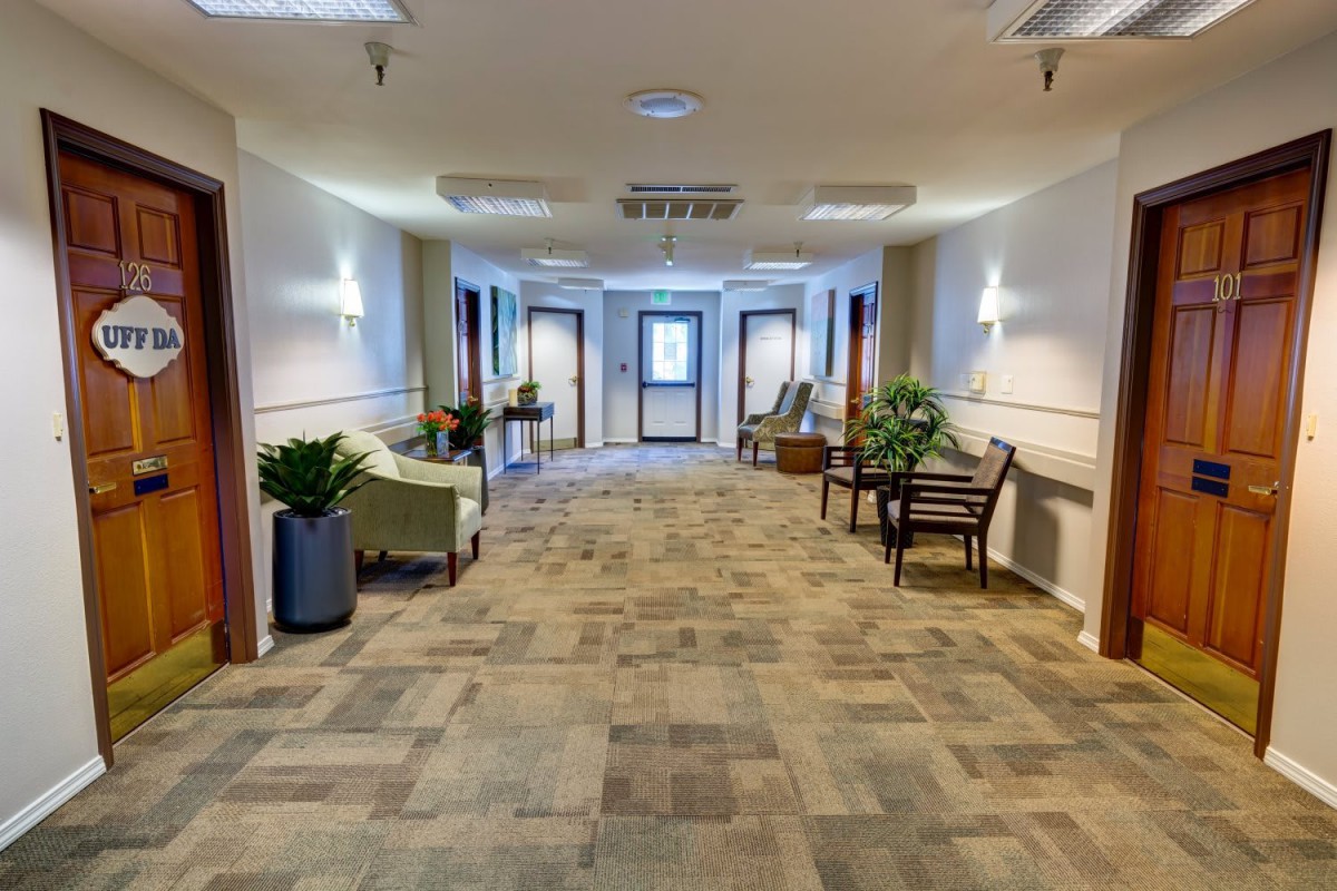 A well-lit hallway with seating and decorative plants.