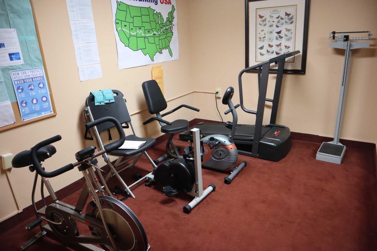 A cozy home gym featuring a treadmill, stationary bike, and fitness equipment.