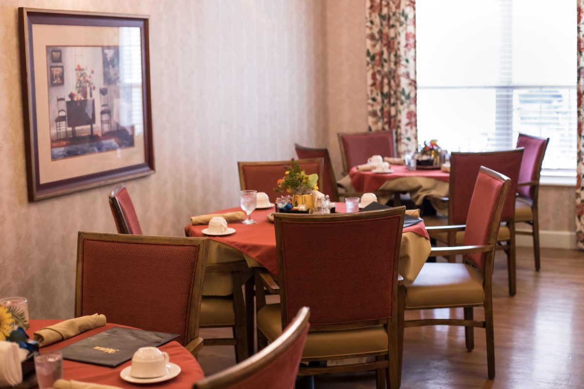 A cozy dining room with tables set for a meal.
