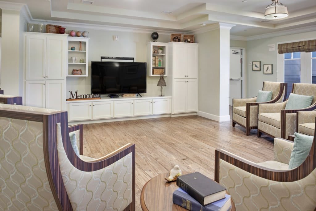 A cozy living room with a television, bookshelves, and comfortable seating.