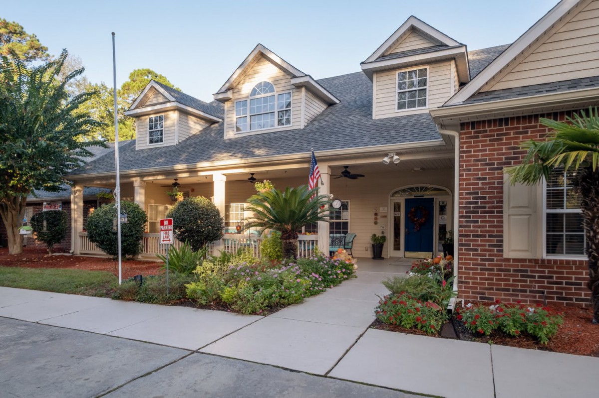 A two-story residential house with a large porch and landscaped front yard.
