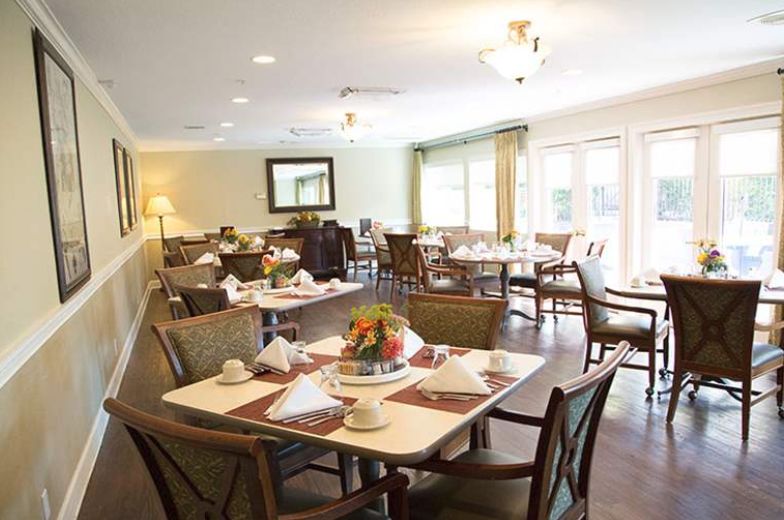 A cozy dining area with elegantly set tables and comfortable seating.