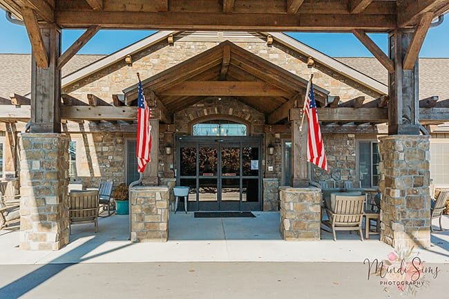 A stone building entrance adorned with American flags.