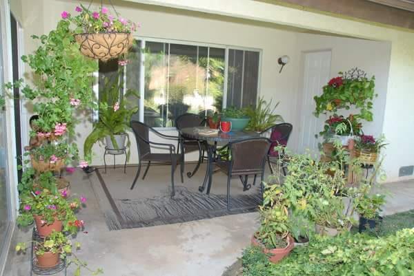 A cozy patio area with outdoor furniture surrounded by lush greenery.
