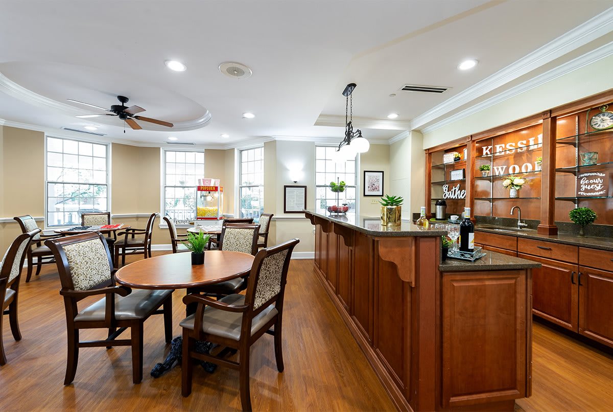 A modern and cozy dining area with wooden furniture and a bar counter, well-lit by natural light.