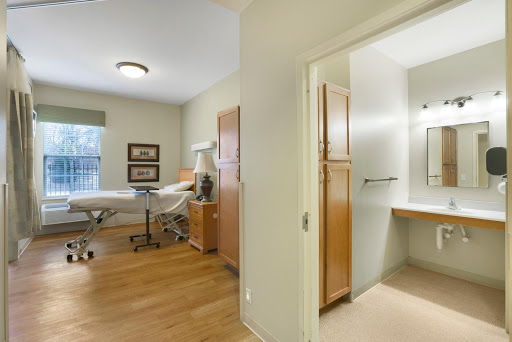 A well-lit medical treatment room featuring a consultation table and modern decor.