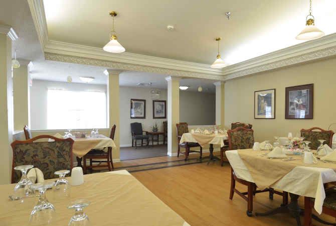 A well-lit dining room with neatly arranged tables and chairs.