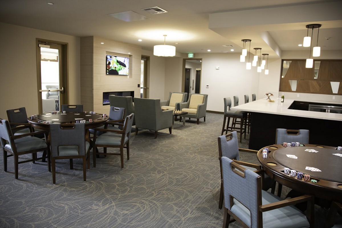 A modern lounge area with seating, tables, and a bar counter.
