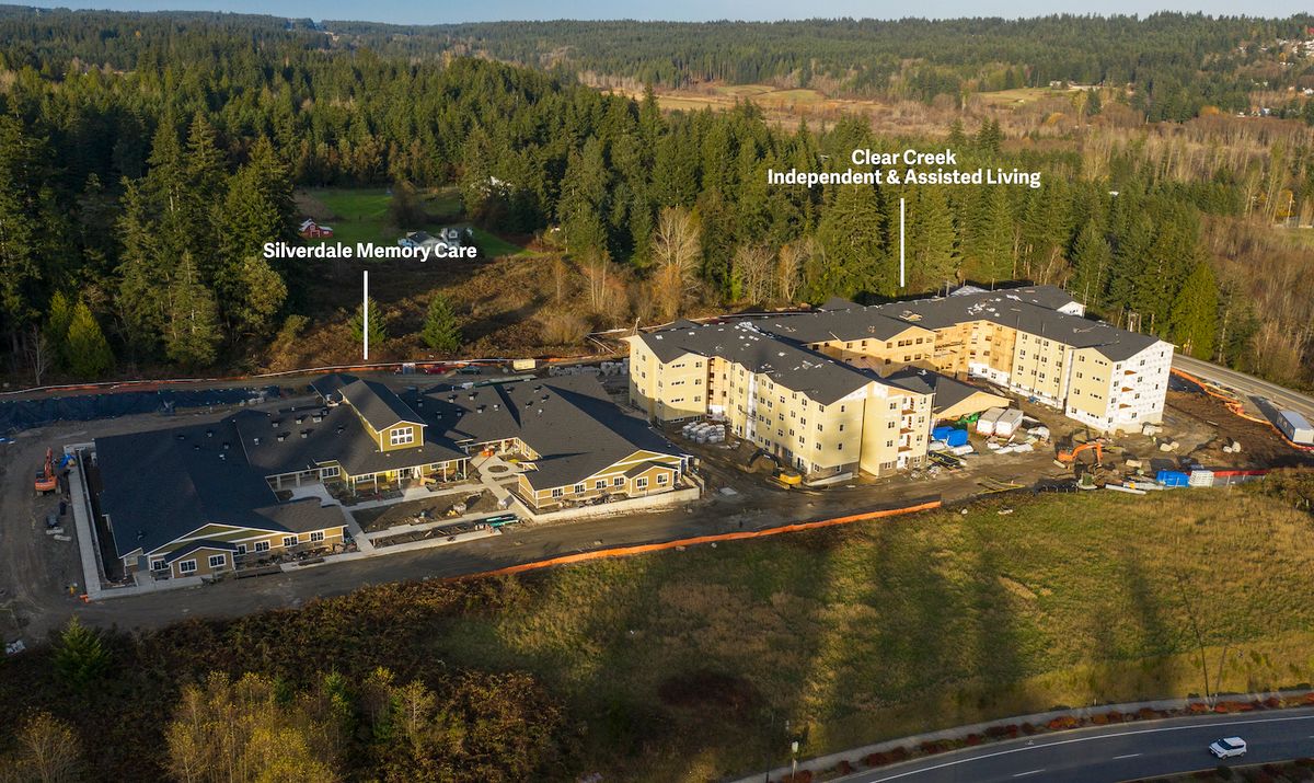 Aerial view of a retirement community surrounded by lush forests.