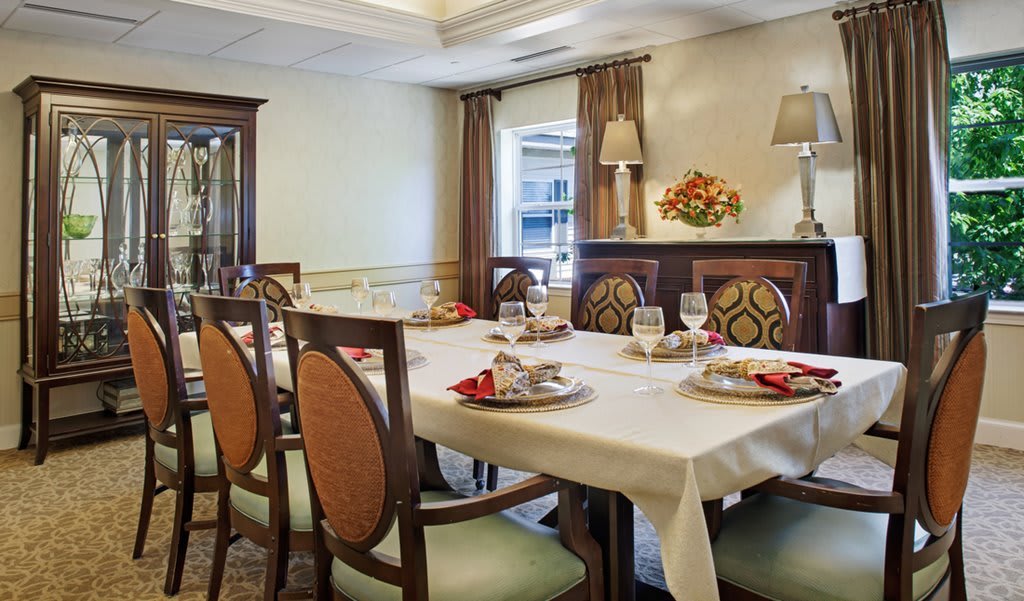 An elegantly decorated dining room with a set table and stylish chairs.