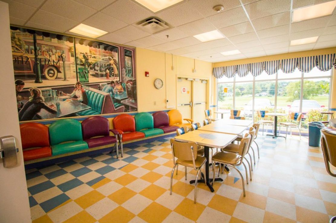A retro-style diner interior with colorful seating and checkered floors.