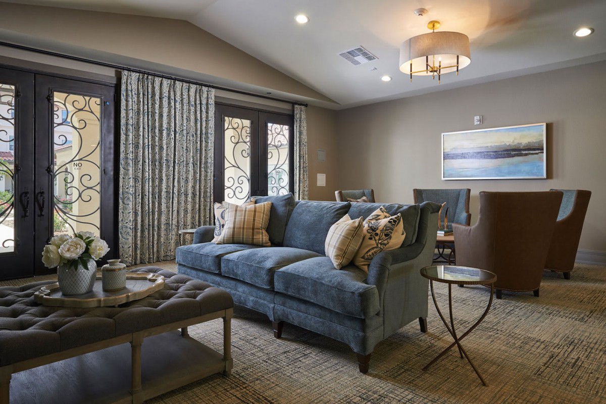 A modern and cozy living room featuring a blue sofa, elegant curtains, and stylish furniture.
