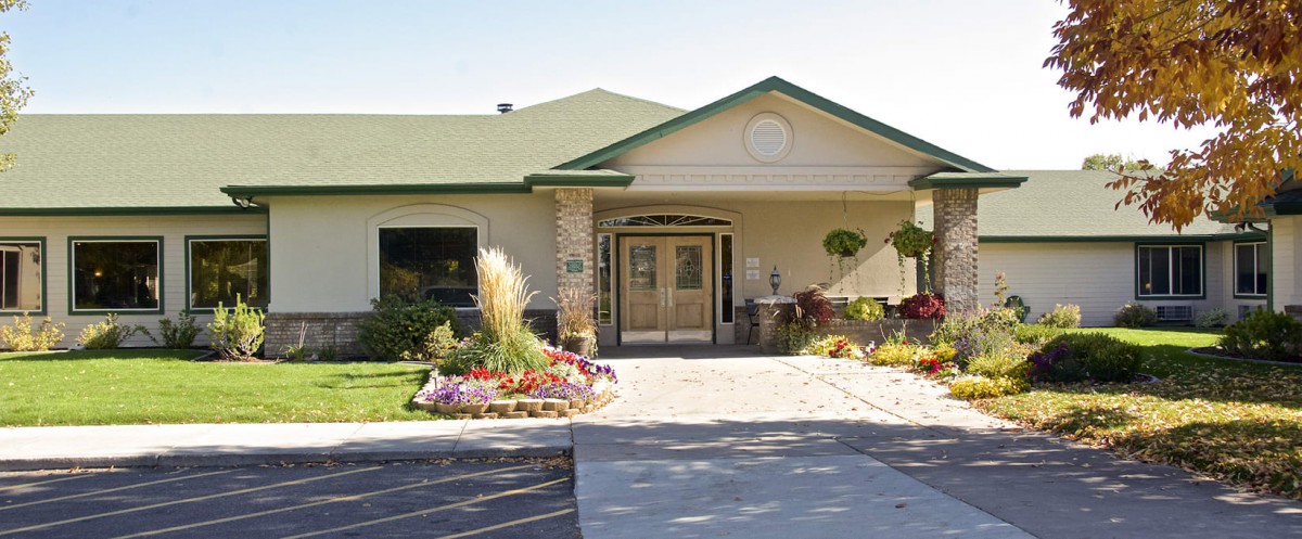 A welcoming building entrance with a green roof and well-maintained landscaping.