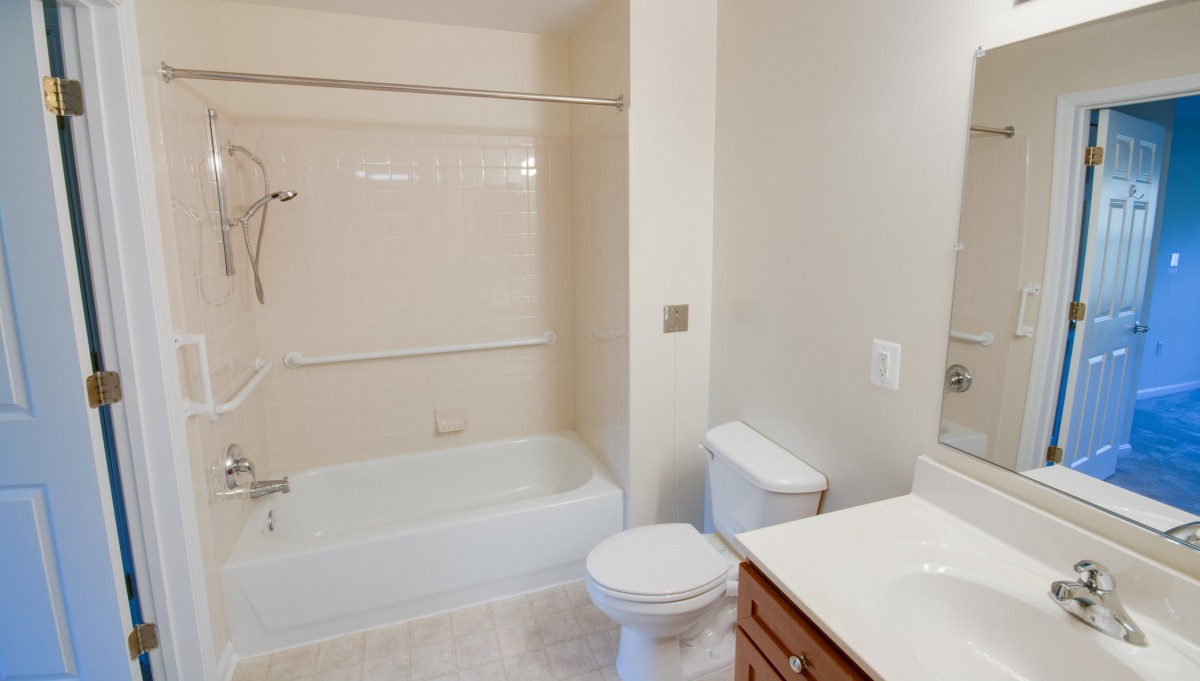 A clean and simple bathroom with a bathtub, toilet, and sink.