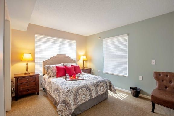 A cozy bedroom with a neatly made bed and warm lighting.