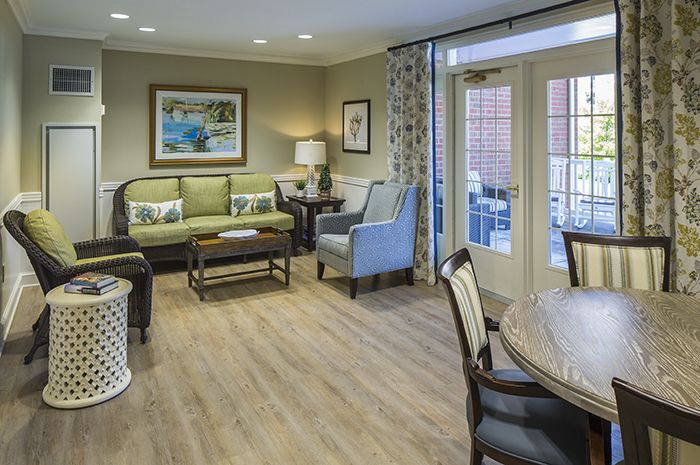 A stylish living room featuring a comfortable seating area, coffee table, and tasteful decor with artwork on the walls.