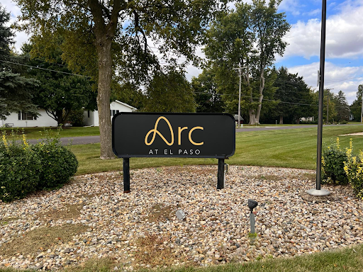 Sign for 'Arc' located in a grassy area.
