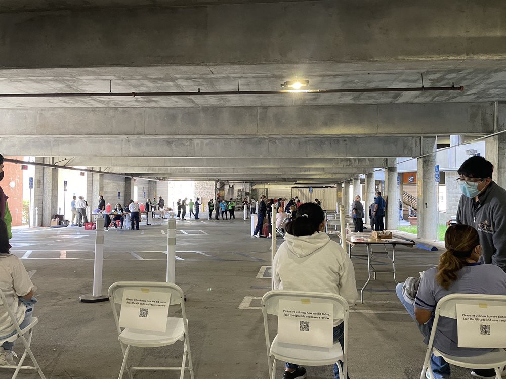 People waiting in a parking garage set up as a vaccination site.