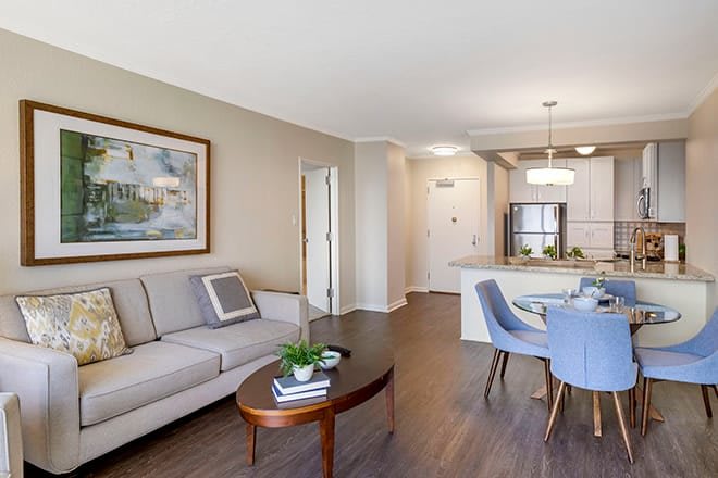 A modern open-concept living and dining area with a view into the kitchen, featuring contemporary furnishings and decor.