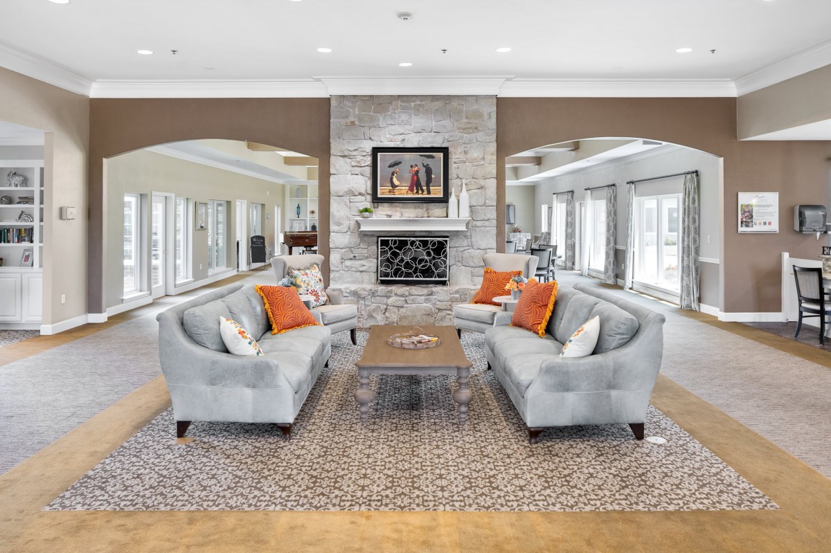 A modern living room with two matching sofas, a central coffee table, and a stylish fireplace adorned with artwork.