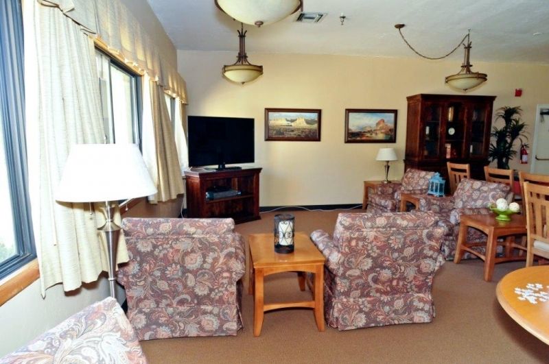 A cozy living room featuring comfortable seating, a large TV, and decorative artwork.