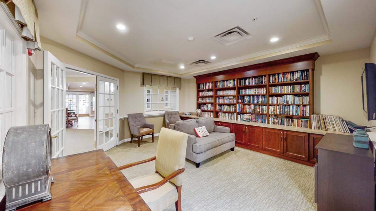 A cozy library room with bookshelves and comfortable seating.
