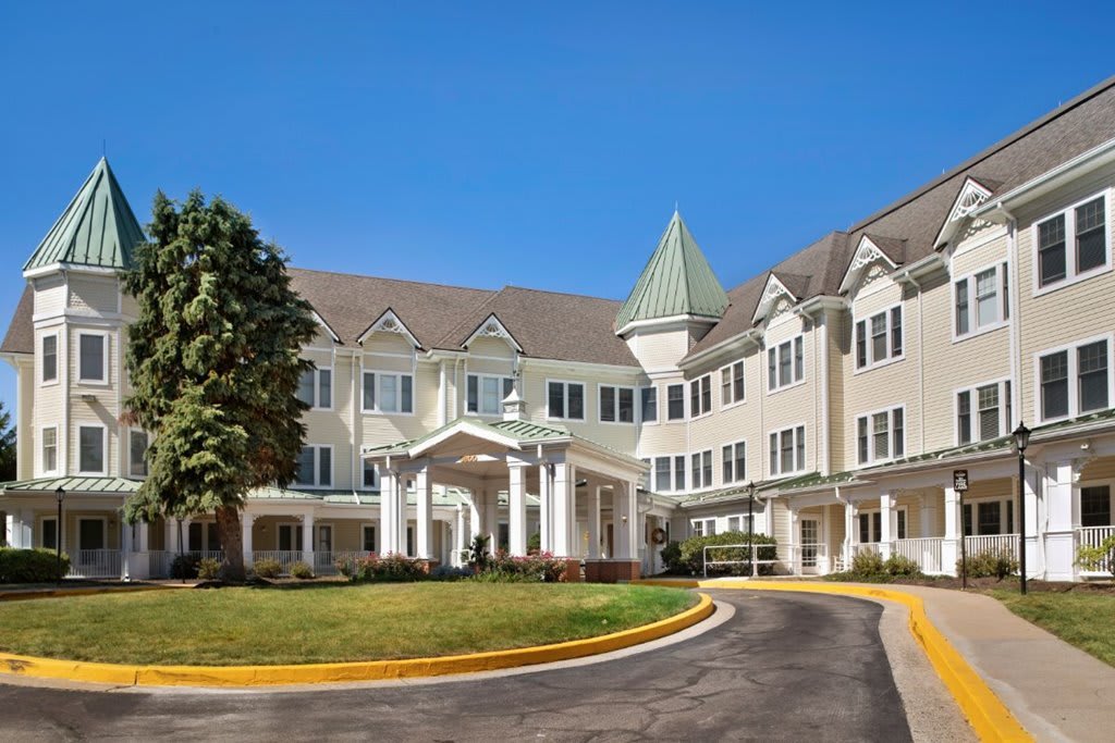 A large, multi-story residential building with decorative architecture and a landscaped entrance.