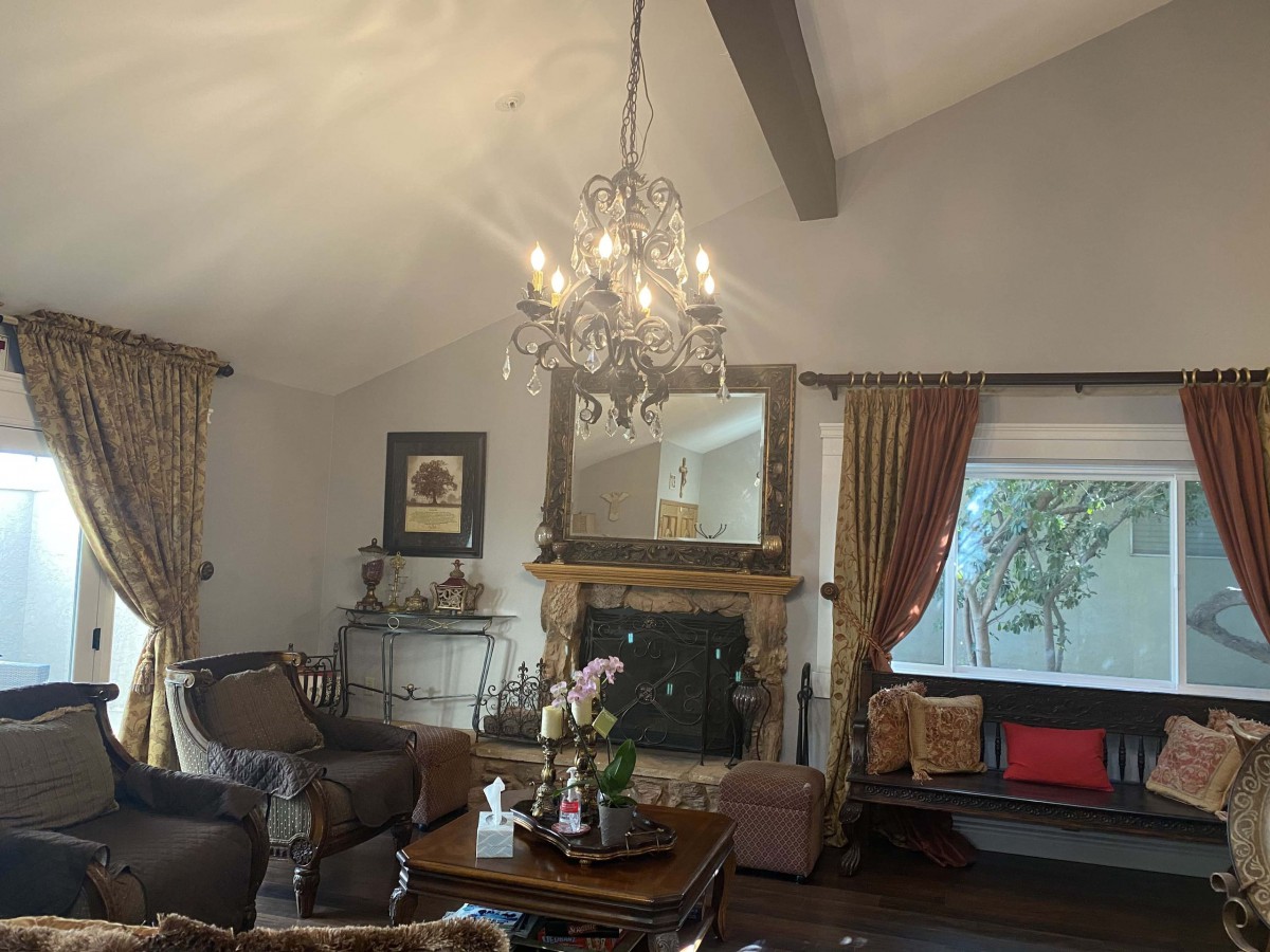 A cozy living room with a chandelier, fireplace, and elegant decor.