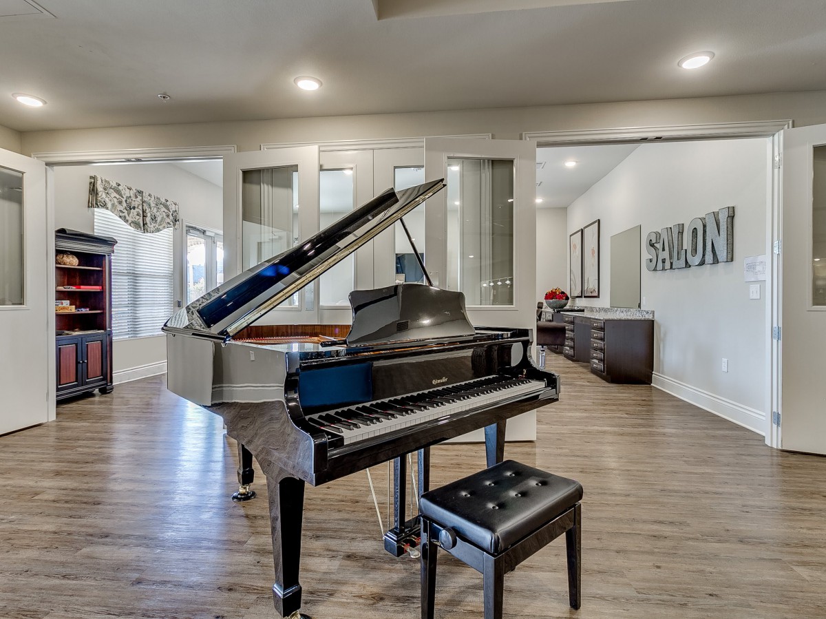 A stylish living room featuring a grand piano on a wooden floor.