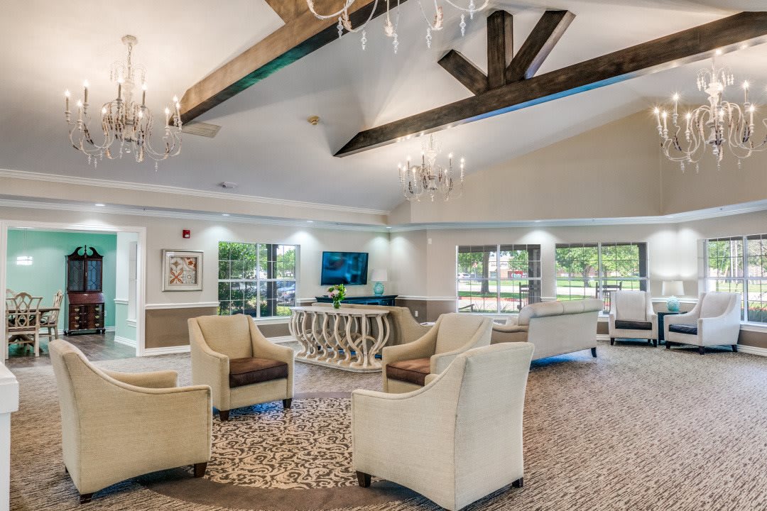 A spacious and elegantly designed lobby with comfortable seating, chandeliers, and exposed beams.