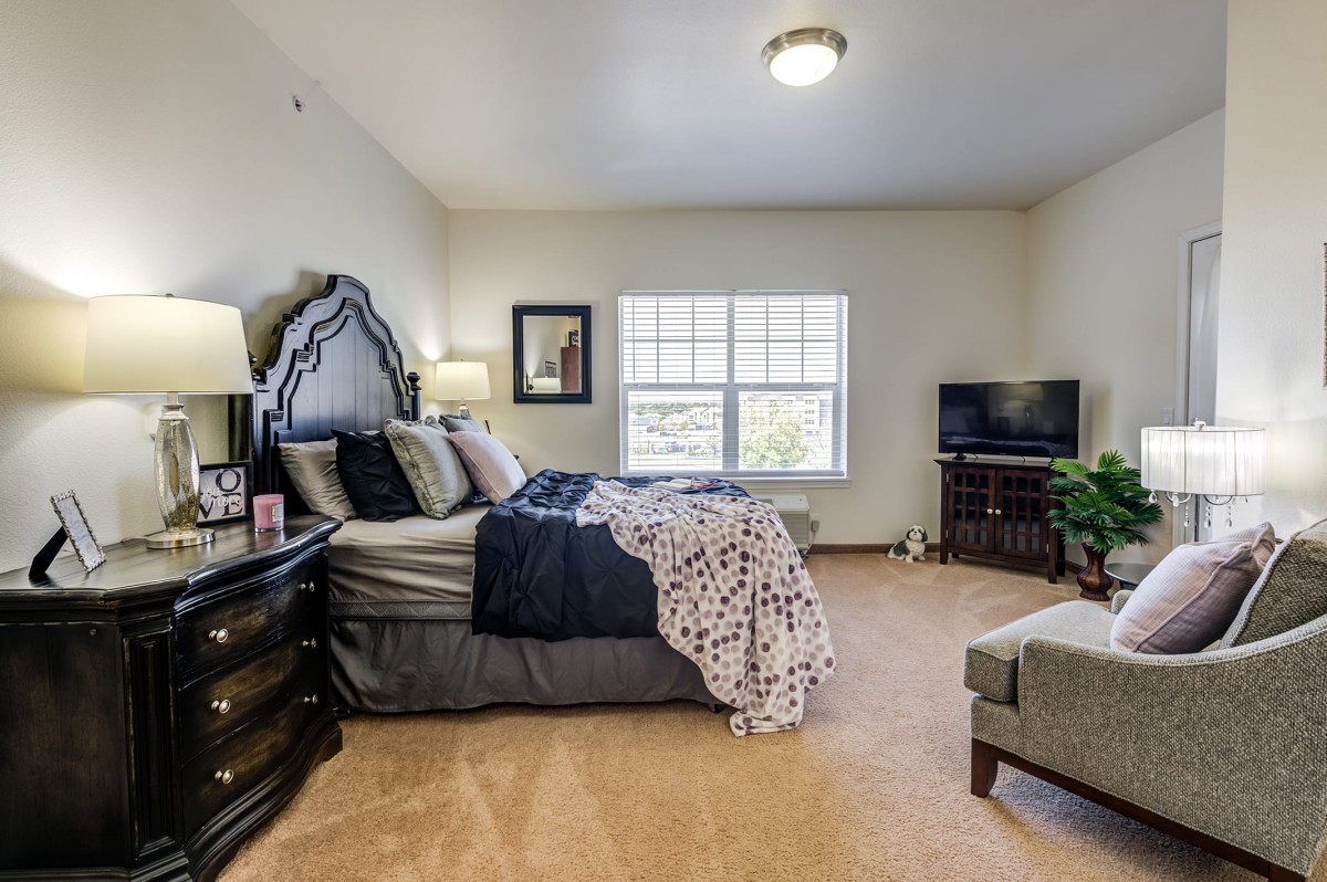 A cozy bedroom with a large bed, elegant decor, and a TV in the corner.