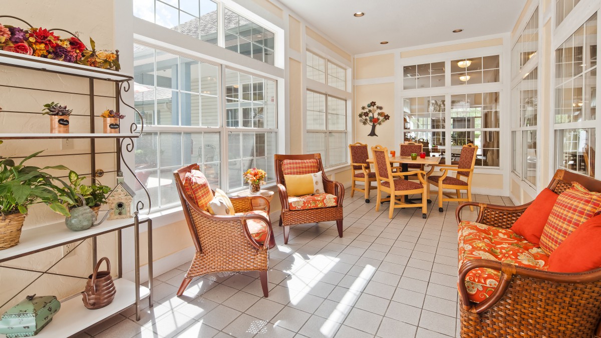 A bright sunroom with comfortable seating and large windows.