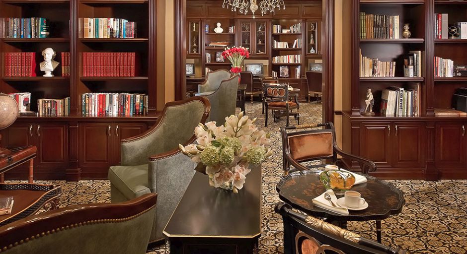 A cozy library setting with wooden furniture, bookshelves, and elegant decor.