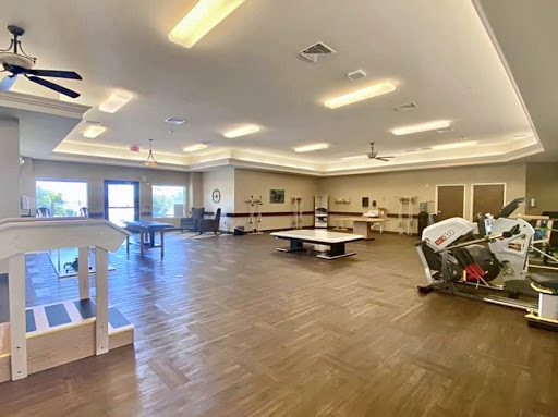 A spacious recreational room featuring wooden flooring and ample lighting.