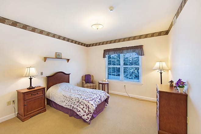 A cozy bedroom with a single bed and classic furnishings.