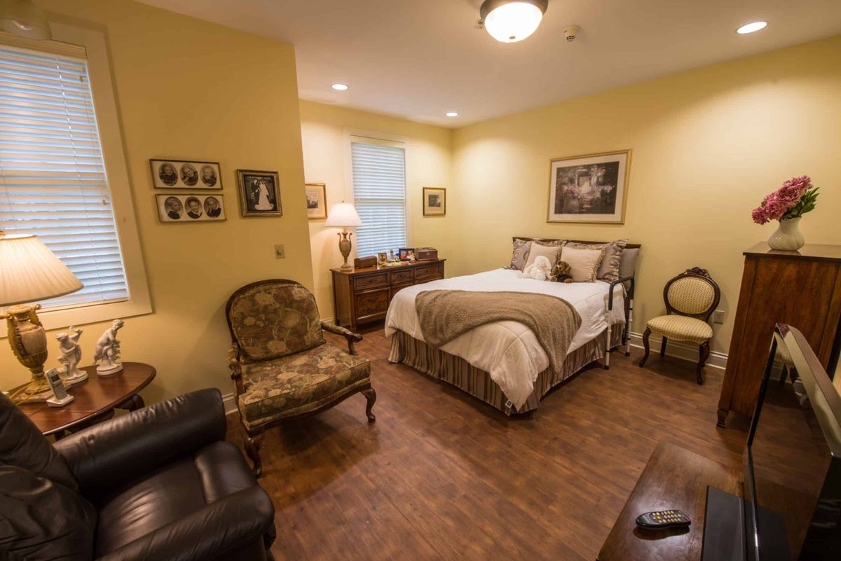 A cozy, traditionally decorated bedroom with warm lighting and comfortable furniture.