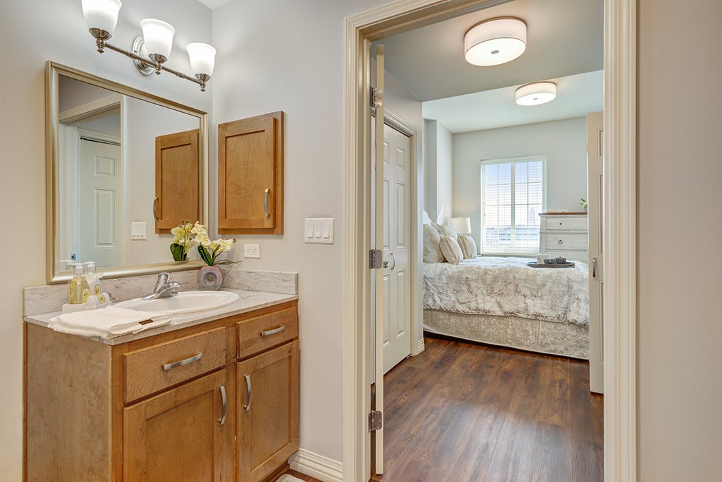 View from the bathroom to the adjoining bedroom with wooden flooring and contemporary decor.