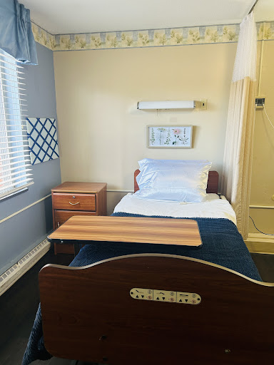 A cozy, well-lit bedroom featuring a single bed and wooden furniture.