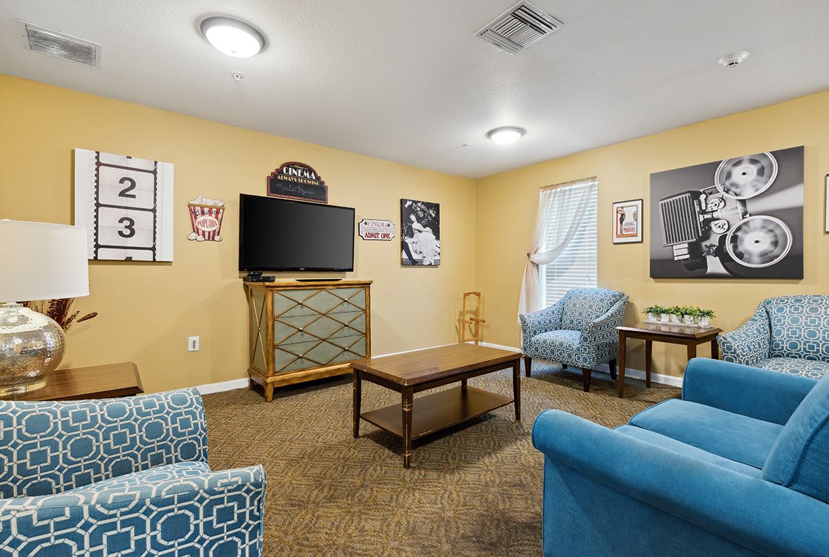A cozy living room area with modern furniture and a wall-mounted television.