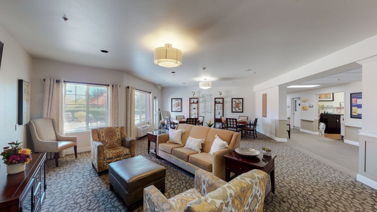 A spacious and well-lit living room with comfortable seating and elegant decor.