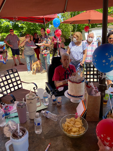 A joyful gathering celebrating a birthday with friends and family outdoors.