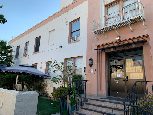 A charming entrance to a residential building with decorative elements and greenery.