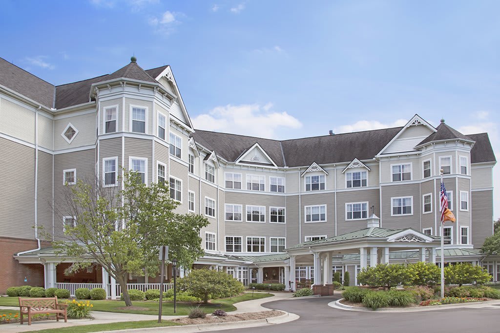 A large residential building with ornate architecture on a sunny day, surrounded by well-maintained landscaping.
